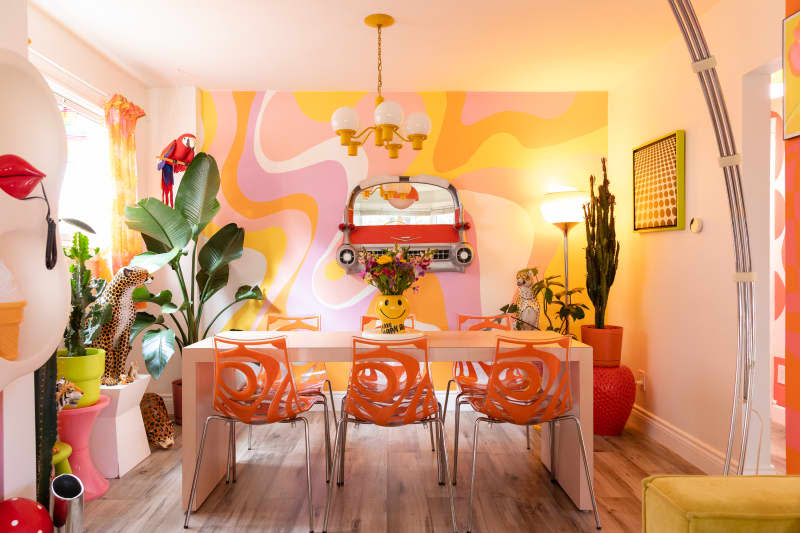 Orange vintage dining chairs in colorful dining room.