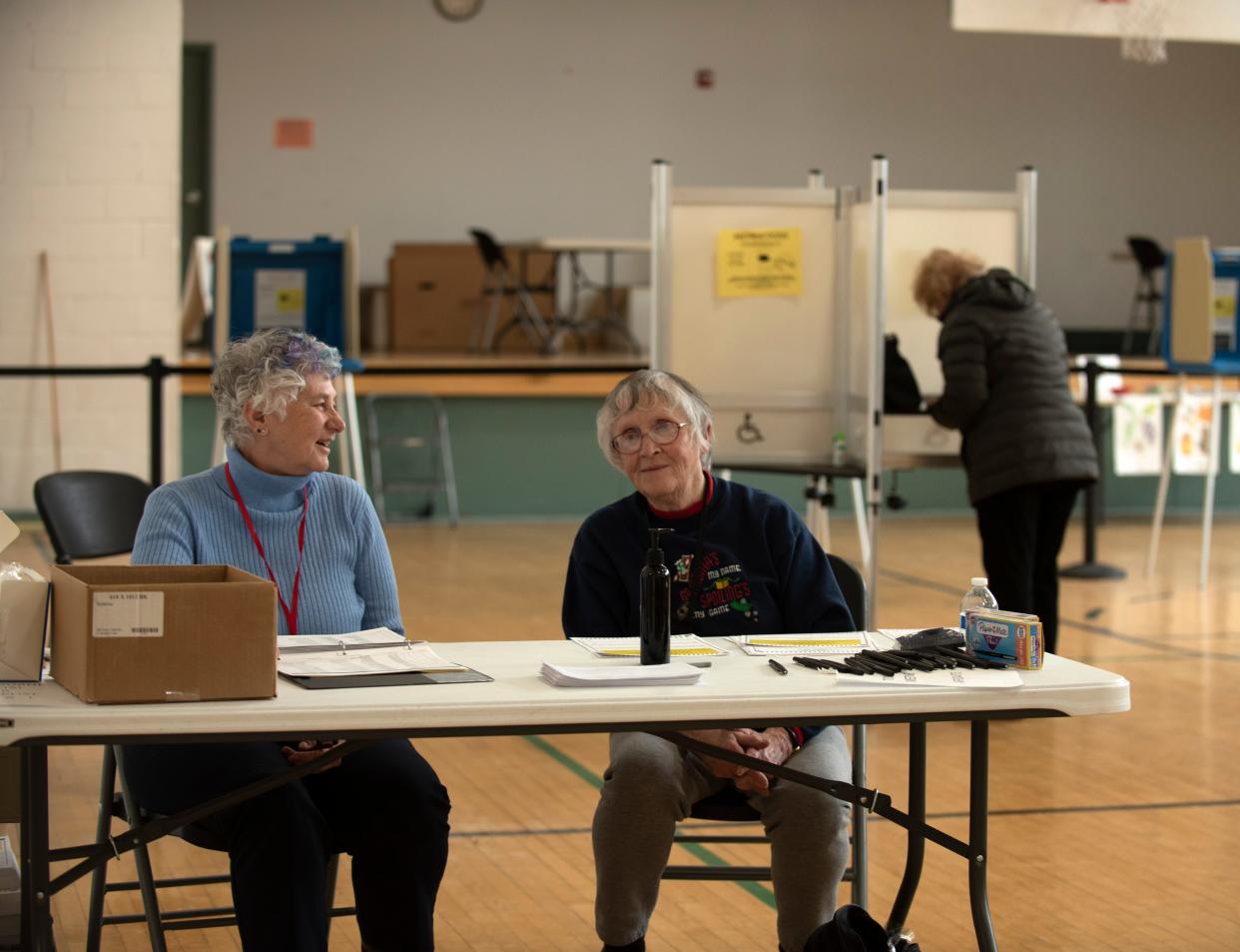 Ballot volunteers Sure Irish, left, and Sally Kalinoski staff the table checking in voters at Shelburne Town Hall on Town Meeting Day, Tuesday, March 7, 2023.