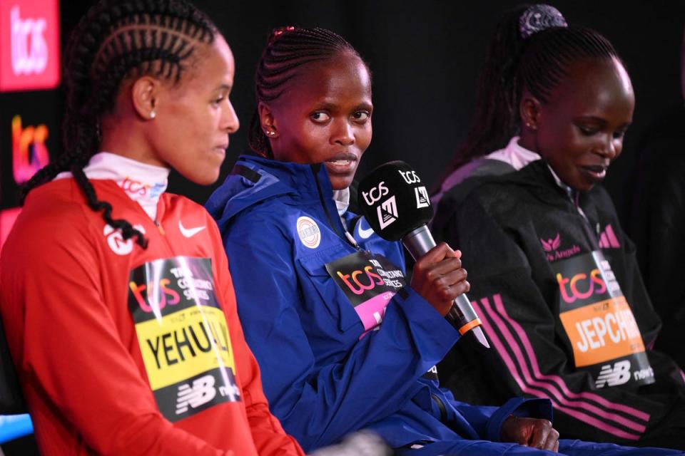 Brigid Kosgei speaks alongside Yalemzerf Yehualaw and Peres Jepchirchir (AFP via Getty Images)