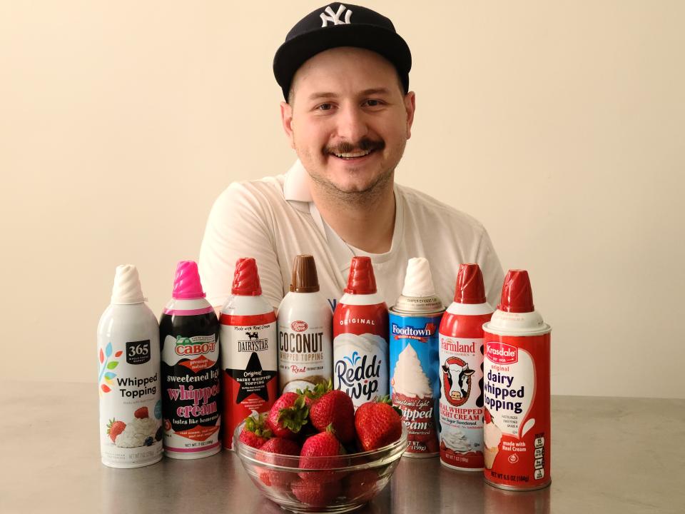 lucien posing with cans of whipped cream and a bowl of strawberries