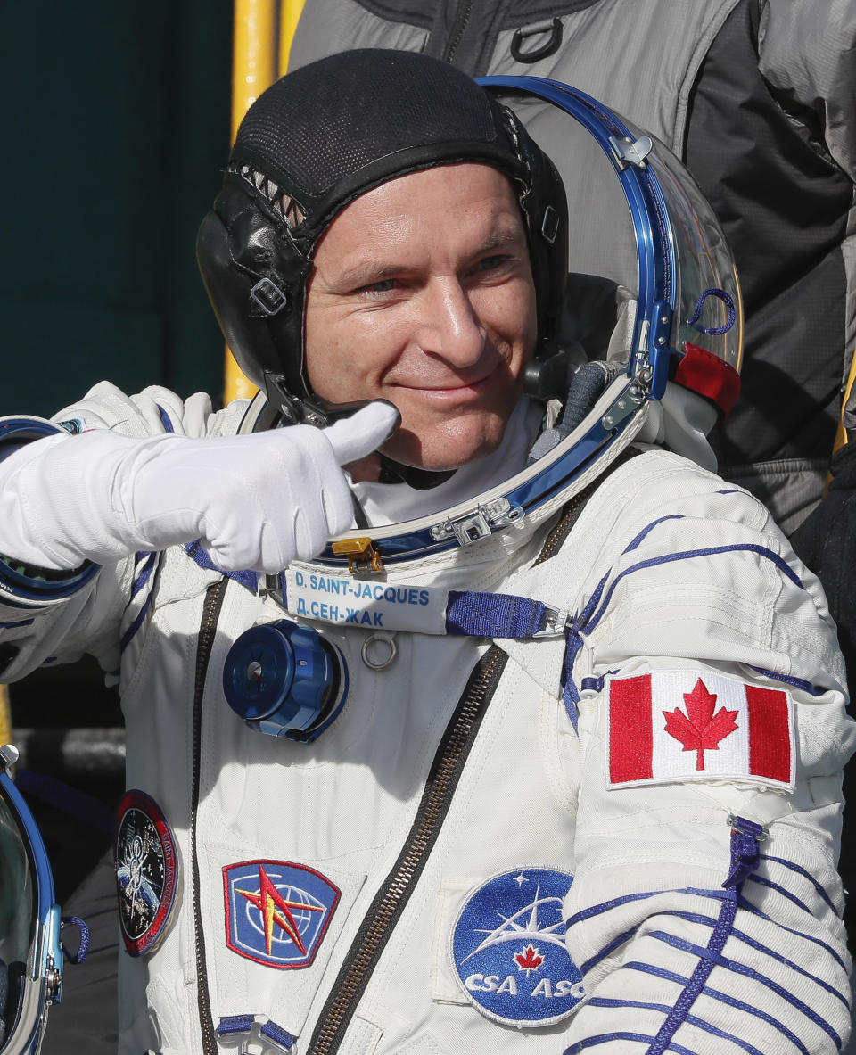 David Saint Jacques, crew member of the mission to the International Space Station, ISS, waves as he boards the rocket prior to the launch of Soyuz-FG rocket at the Russian leased Baikonur cosmodrome, Kazakhstan, Monday, Dec. 3, 2018. (AP Photo/Shamil Zhumatov, Pool)