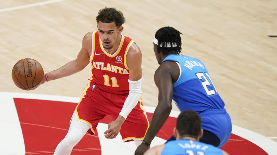 Atlanta Hawks' Trae Young (11) dribbles against Milwaukee Bucks' Jrue Holiday (21) during the first half of Game 3 of the NBA Eastern Conference basketball finals Sunday, June 27, 2021, in Atlanta. (AP Photo/Brynn Anderson)