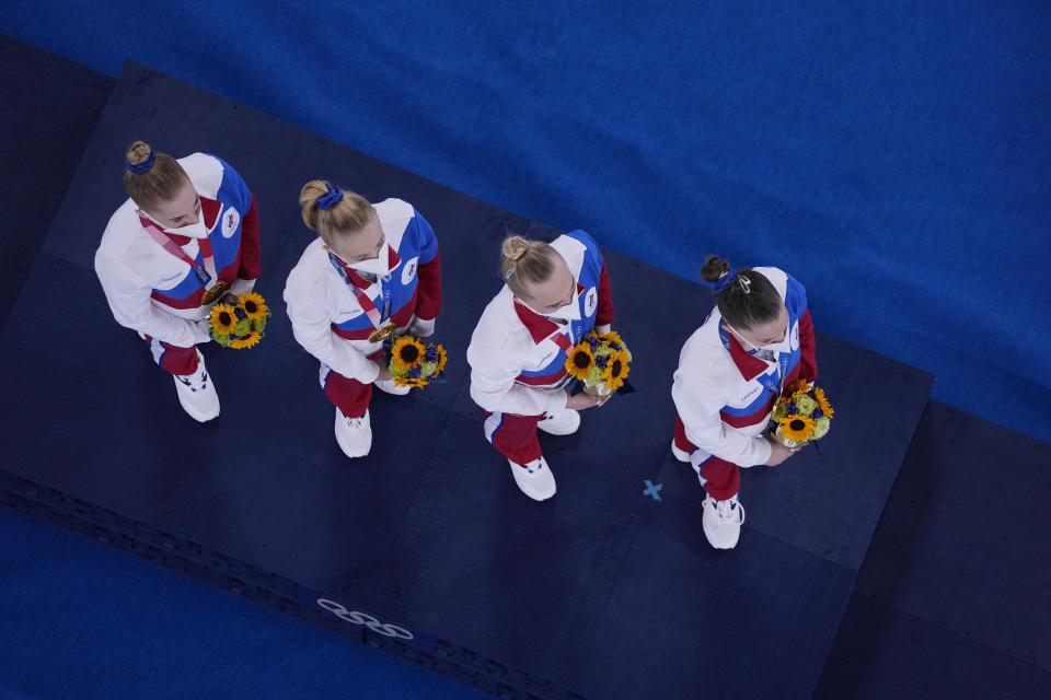 Russian Olympic Committee's artistic gymnastics women's team, Liliia Akhaimova, Viktoriia Listunova, Angelina Melnikova and Vladislava Urazova listen to music from a Russian composer during the medal ceremony after receiving theirs gold medals at the 2020 Summer Olympics, Tuesday, July 27, 2021, in Tokyo. (AP Photo/Morry Gash)