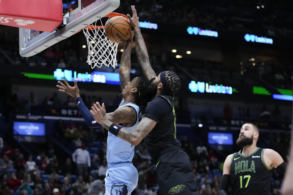 New Orleans Pelicans forward Brandon Ingram blocks a layup by Memphis Grizzlies guard Ja Morant in the first half of an NBA basketball game in New Orleans, Tuesday, Dec. 26, 2023. (AP Photo/Gerald Herbert)