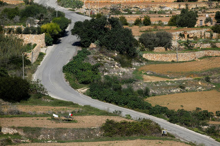 A flag and banner mark the site where investigative journalist Daphne Caruana Galizia was assassinated in a car bomb last year, as seen from the look-out point used by her alleged assassins, in the run-up to activities marking one year since her murder, in Bidnija, Malta October 15, 2018. REUTERS/Darrin Zammit Lupi