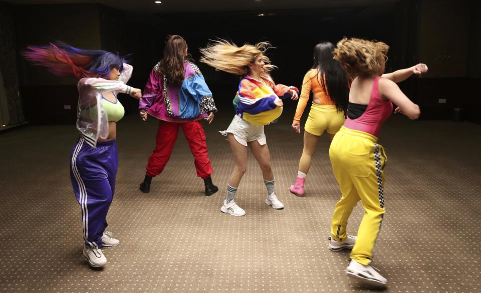 Catherine Gallano, dancer and lead choreographer, center, dances with her group during their livestream performance on social media for followers who send them money, in Dubai, United Arab Emirates, Thursday, Nov. 5, 2020. As the coronavirus pandemic mutes Dubai's live-music scene, the Filipino show bands that long have animated the city's storied nightlife are being disproportionately squeezed. Many are out of work and out of money, struggling to survive in overcrowded dormitories at the mercy of employers (AP Photo/Kamran Jebreili)