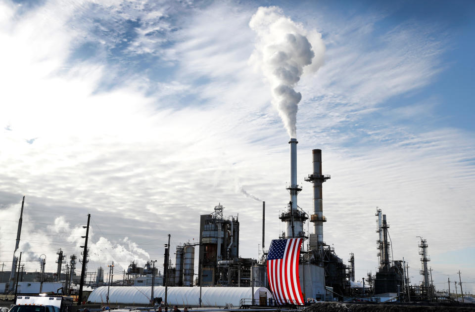 FILE - A flag hangs on the side of the Andeavor Mandan Refinery in Mandan, N.D., Sept. 6, 2017. Nineteen Republican state attorneys general have asked the U.S. Supreme Court to get involved in a dispute over climate-change lawsuits. (AP Photo/Charlie Neibergall, File)