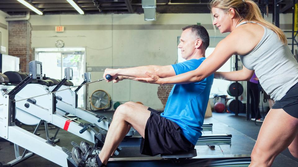 Personal trainer working with her client at a gym.