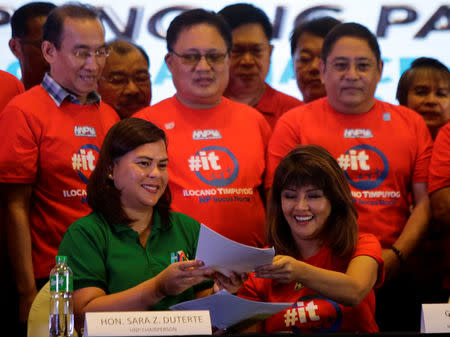 Davao City Mayor Sara Duterte-Carpio (L) and Ilocos Norte Governor Imee Marcos hold a document during an alliance meeting with local political parties in Paranaque, Metro Manila in Philippines, August 13, 2018. REUTERS/Czeasar Dancel