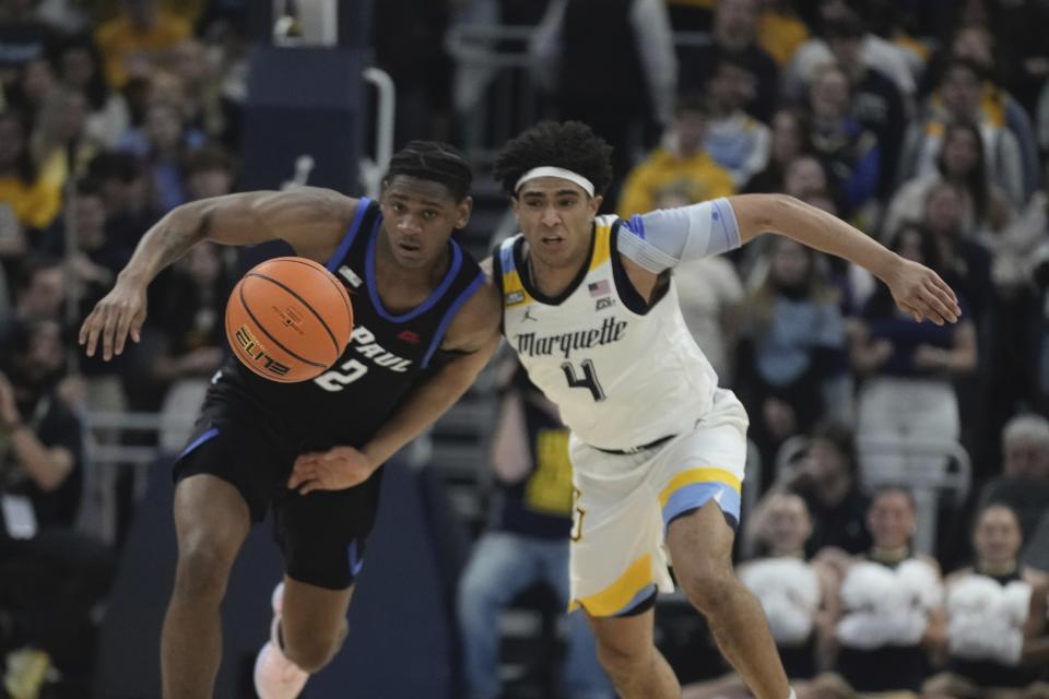 Marquette's Stevie Mitchell and DePaul's Elijah Fisher go after a loose ball during the first half of an NCAA college basketball game Wednesday, Feb. 21, 2024, in Milwaukee. (AP Photo/Morry Gash)