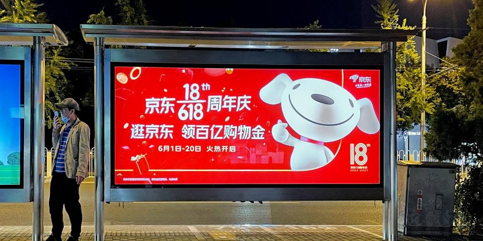 JD.com is reported to have started laying off 400 to 600 employees in recent weeks. Here, a man stands next to a billboard advertising JD.com 618 Shopping Festival on May 29, 2021 in Beijing, China.