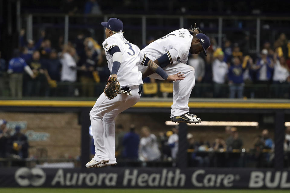 Milwaukee Brewers' Orlando Arcia (3) and Lorenzo Cain (6) celebrate after Game 6 of the National League Championship Series baseball game against the Los Angeles Dodgers Friday, Oct. 19, 2018, in Milwaukee. The Brewers won 7-2. (AP Photo/Jeff Roberson)