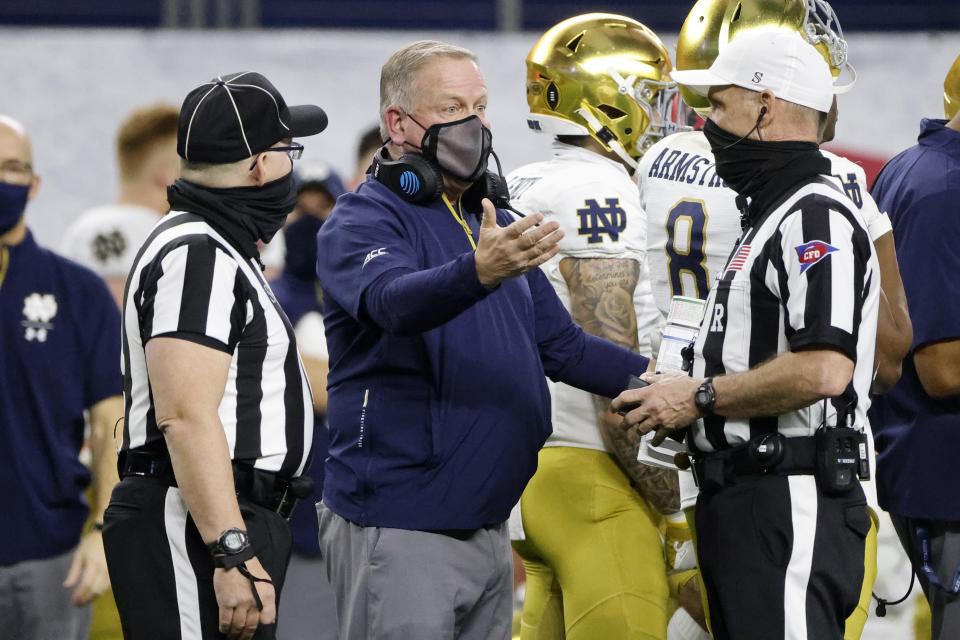 Notre Dame head coach Brian Kelly, center, talks to officials in the first half of the Rose Bowl NCAA college football game against Alabama in Arlington, Texas, Friday, Jan. 1, 2021. (AP Photo/Michael Ainsworth)