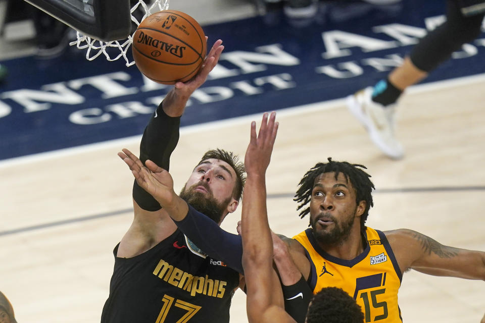 Memphis Grizzlies center Jonas Valanciunas (17) and Utah Jazz center Derrick Favors (15) battle for a rebound in the first half during an NBA basketball game Saturday, March 27, 2021, in Salt Lake City. (AP Photo/Rick Bowmer)