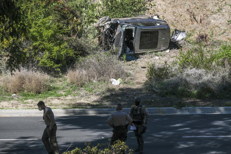 FILE - In this Feb. 23, 2021, file photo a vehicle rests on its side after a rollover accident involving golfer Tiger Woods along a road in the Rancho Palos Verdes suburb of Los Angeles. A man who found Woods unconscious in a mangled SUV last week after the golf star who later told sheriff's deputies he did not know how the collision occurred and didn't even remember driving, crashed the vehicle in Southern California, authorities said in court documents. Law enforcement has not previously disclosed that Woods had been unconscious following the collision. (AP Photo/Ringo H.W. Chiu, File)