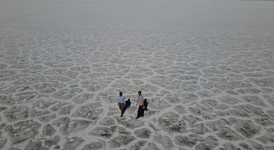 State of Utah Department of Natural Resources geologists Paul Inkenbrandt, left, and Jeremiah Bernau walk along the Bonneville Salt Flats on Aug. 29, 2022, near Wendover, Utah. The glistening white salt of the world famous area is shrinking near the Utah-Nevada line. (AP Photo/Rick Bowmer)