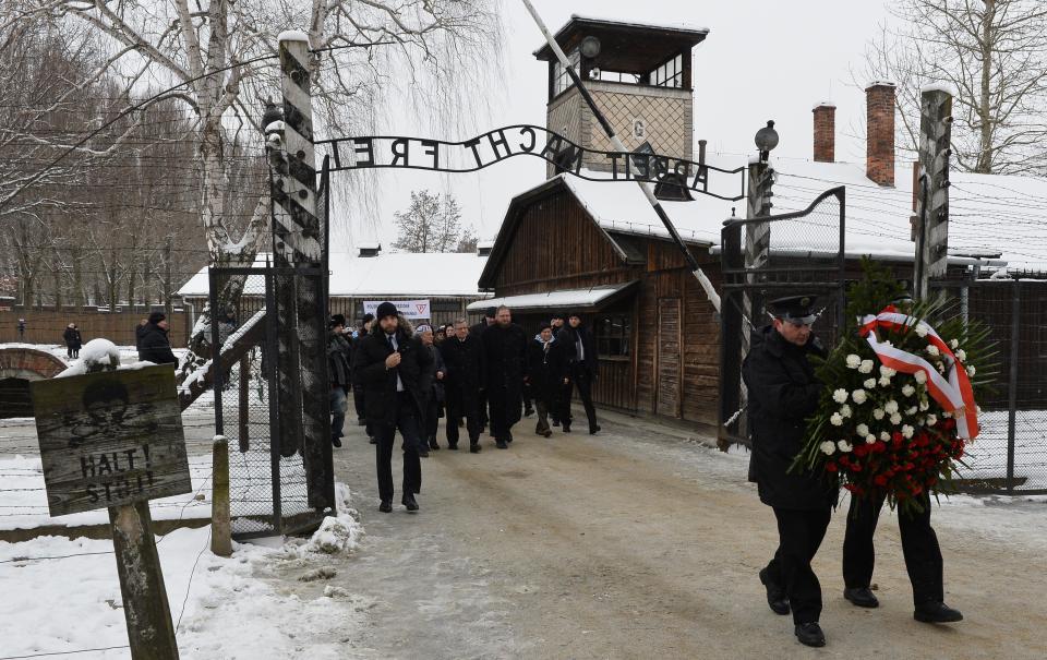 Polish President Bronislaw Komorowski (C), Piotr Cywinski (C-R), director of the Auschwitz-Birkenau museum and Auschwitz survivors arrive to lay down a wreath at the former Auschwitz concentration camp on January 27, 2015 at the camp's memorial site in Oswiecim, Poland. Seventy years after the liberation of Auschwitz, ageing survivors and dignitaries gather at the site synonymous with the Holocaust to honour victims and sound the alarm over a fresh wave of anti-Semitism. 