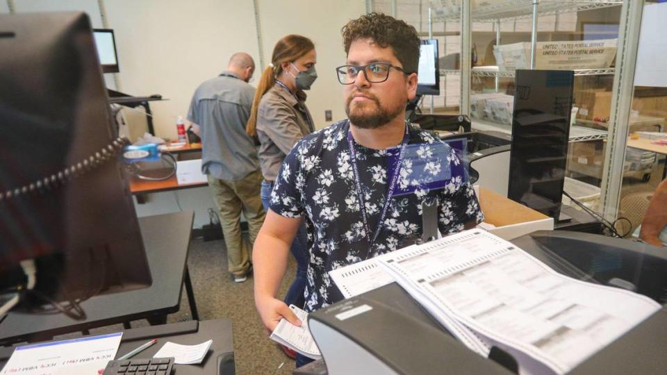 Israel Ruvalcaba counts ballots at the San Luis Obispo County Clerk-Recorder’s office on Tuesday, June 14, 2022. In the background are poll workers Chad Hildebrand and Melissa Lile.
