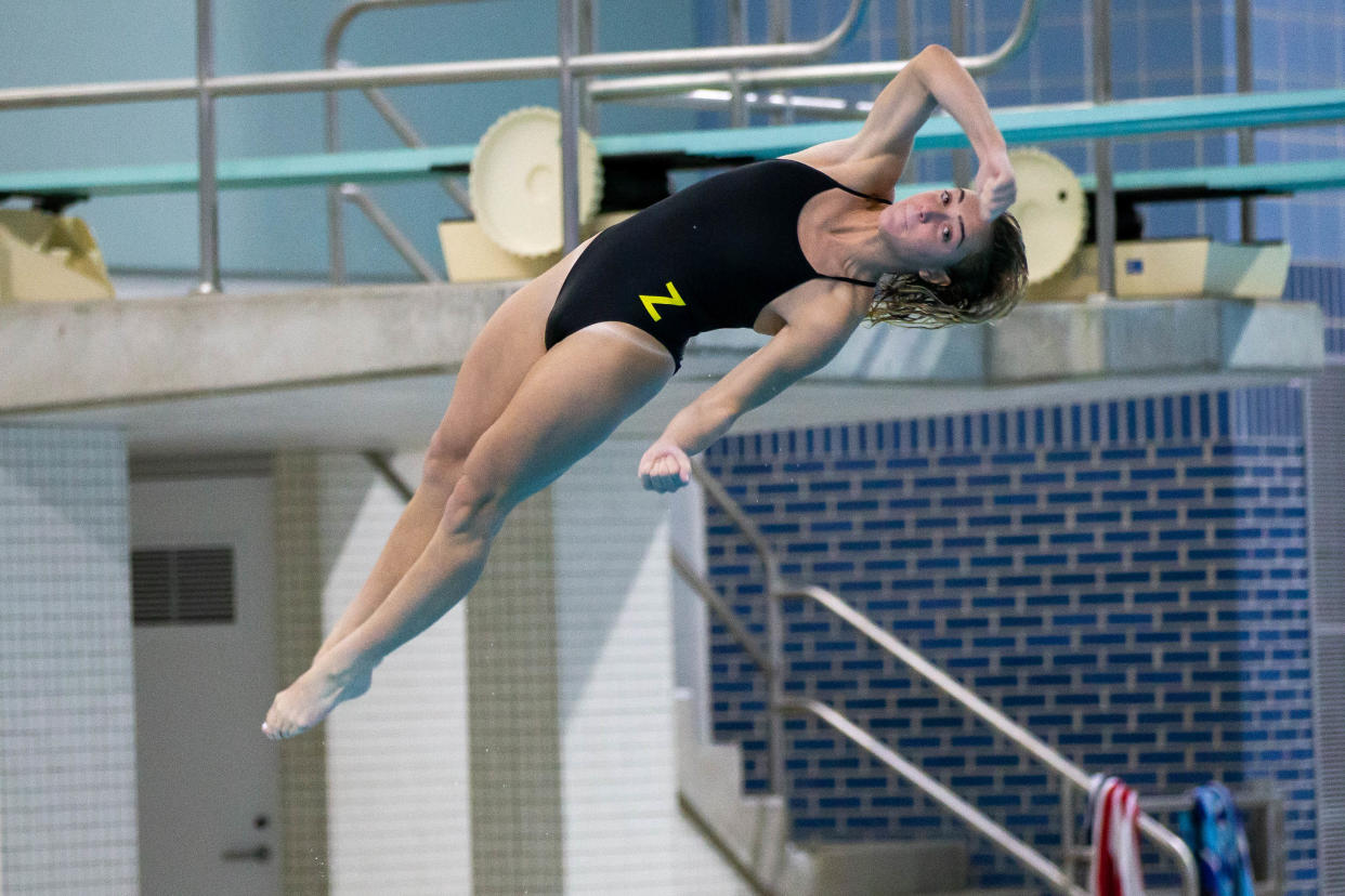 Zeeland's Sadie Huizenga jumps off the diving board Tuesday, Oct. 25, 2022, at the Holland Aquatic Center. 