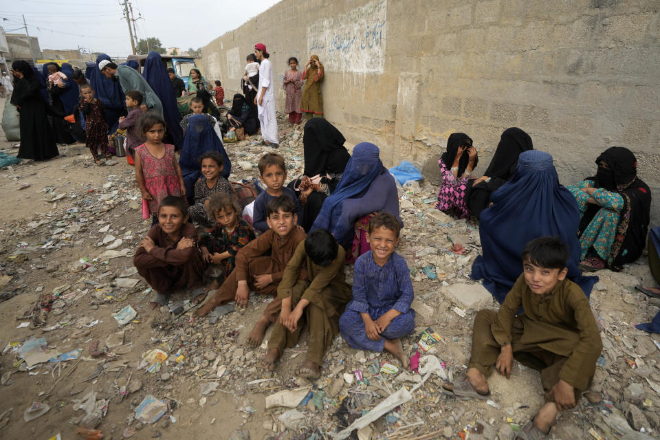 Afghan families wait to board into a bus to depart for their homeland, in Karachi, Pakistan, Friday, Oct. 6, 2023. Pakistan's government announced a major crackdown Tuesday on migrants in the country illegally, saying it would expel them starting next month and raising alarm among foreigners without documentation who include an estimated 1.7 million Afghans. (AP Photo/Fareed Khan)