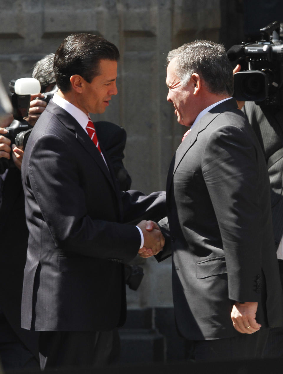 Mexico's President Enrique Pena Nieto, left, and King Abdullah II of Jordan embrace during a welcoming ceremony at the National Palace in Mexico City, Thursday, Feb. 6, 2014. King Abdullah II is in Mexico in an official visit upon invitation from the President and will also meet with political and economic leaders to discuss means of strengthening bilateral relations. (AP Photo/Marco Ugarte)