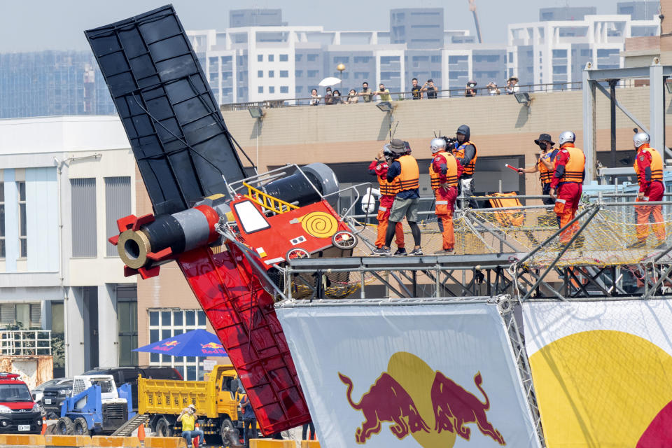 Team members watch as their man made flying machine leans over the edge at the harbor in Taichung, a port city in central Taiwan on Sunday, Sept. 18, 2022. Pilots with homemade gliders launched themselves into a harbor from a 20-foot-high ramp to see who could go the farthest before falling into the waters. It was mostly if not all for fun as thousands of spectators laughed and cheered on 45 teams competing in the Red Bull “Flugtag” event held for the first time. (AP Photo/Szuying Lin)