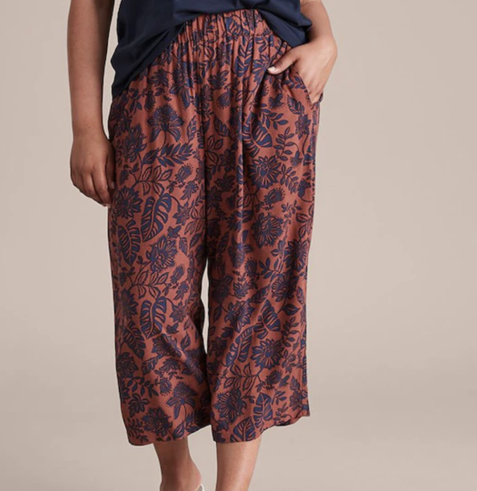 Lower torso and legs of woman wearing rust and purple tropical print trousers, $25, from Target