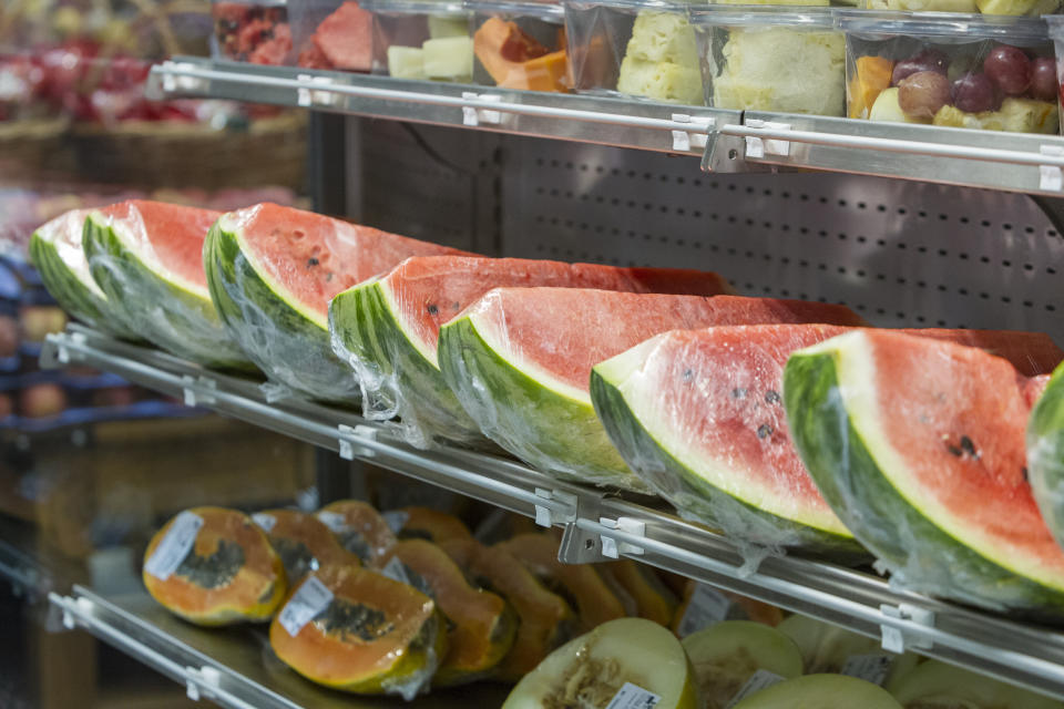 pre-cut and packaged watermelon quarters on the shelf of a grocery store