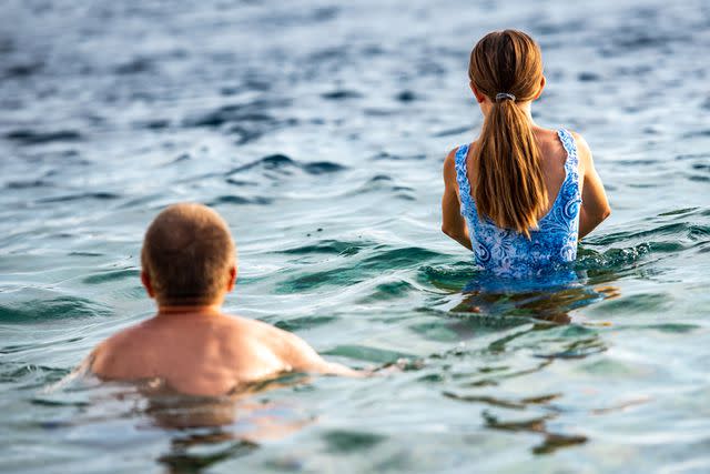 <p>Getty</p> Stock image of father and daughter swimming in the ocean.