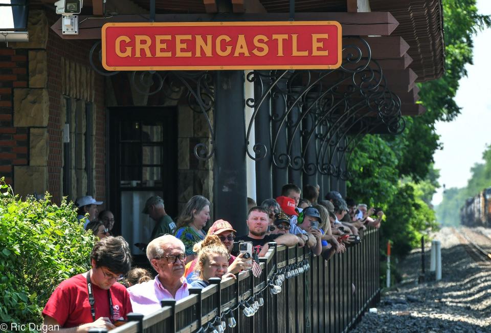People line the fence to watch at the historic High Line Train Station in Greencastle to watch the steam locomotive 611 come through town on Thursday.