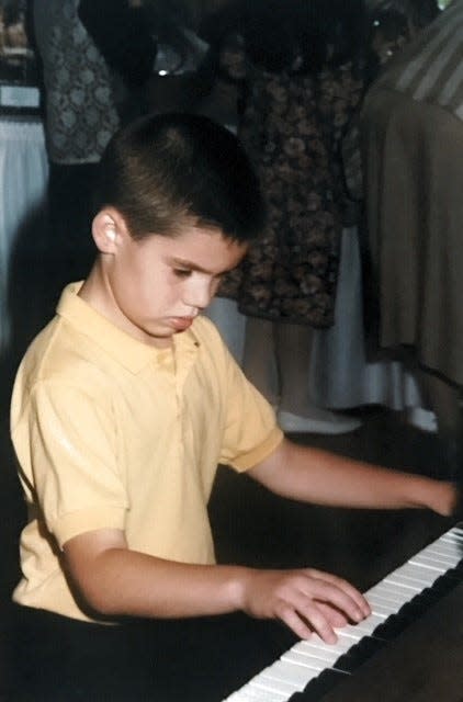 Arizona Diamondbacks hitting coach Drew Hedman is seen playing a piano as an 8-year-old in a photo taken by his father, Andy Hedman, in 1994.