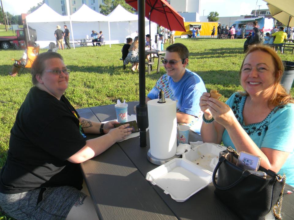 Danyelle Foster, from left, Caitlyn Little and Laura Carrington eat at the Inaugural Oak Ridge Food Truck Rally in fall 2022.