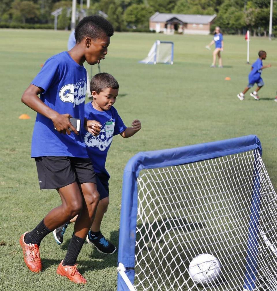 A group of teens set up and ran a soccer camp for 25 youngsters ages 5 to 8 from the Rock Hill Boys and Girls Club. Three days of fun, big brothering and big sistering, and life lessons that were more than soccer. The camp was held at the Manchester Meadows soccer complex. Isaiah Reid celebrates as camper Andre Maldonado,7, kicks one in the goal at soccer camp.