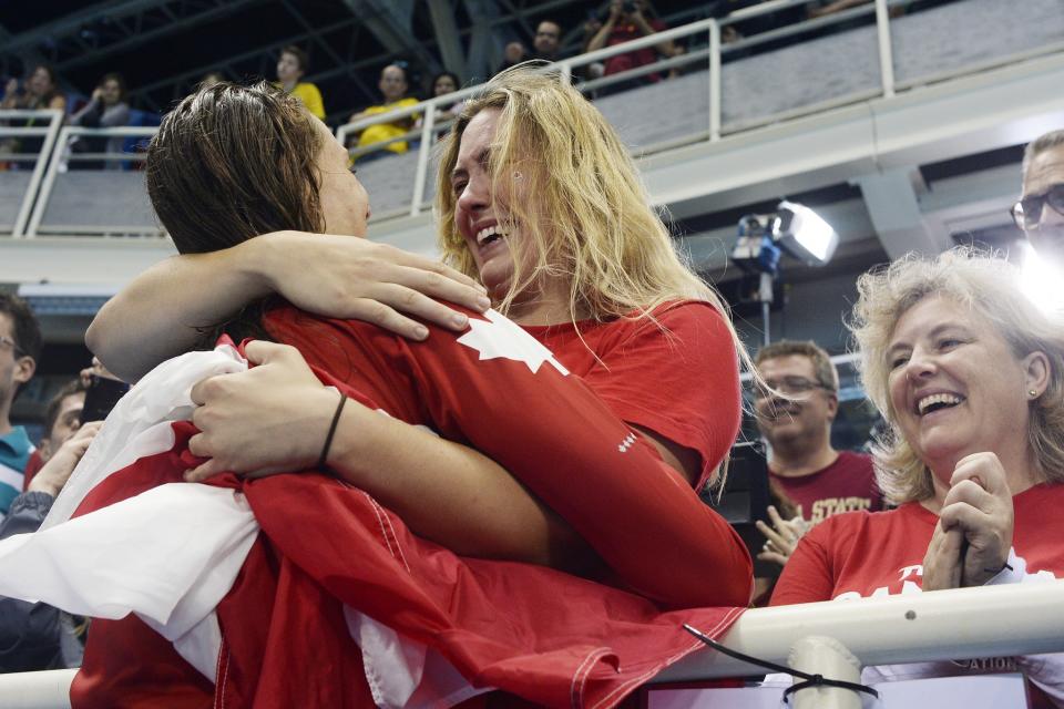 <p>Penny Oleksiak of Canada hugs her sister Hayley after tying for gold in the women’s 100-meter freestyle final at Rio 2016 on Thursday, August 11, 2016. (Photo by AAron Ontiveroz/The Denver Post via Getty Images) </p>