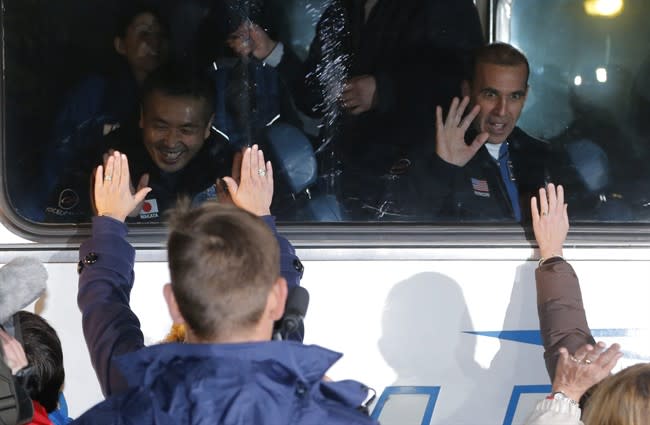 Japanese astronaut Koichi Wakata, left, and U.S. astronaut Rick Mastracchio, crew members of the mission to the International Space Station (ISS) wave to their relatives and friends from a bus prior the launch of a Soyuz-FG rocket at the Russian leased Baikonur cosmodrome, Kazakhstan, Thursday, Nov. 7, 2013. (AP Photo/Dmitry Lovetsky)