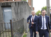 Democratic Unionist Party members Edwin Poots and Paul Girvan, right, leave the party headquarters in east Belfast after voting took place to elect a new leader on Friday May 14, 2021. Edwin Poots and Jeffrey Donaldson are running to replace Arlene Foster. (AP Photo/Peter Morrison)