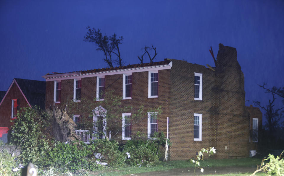 A two story brick home is left with no roof on Haversham Close in Virginia Beach, Va., after a late afternoon storm moved through on Sunday, April 30, 2023. (Billy Schuerman/The Virginian-Pilot via AP)