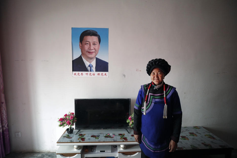 A minority Yi woman stands inside her apartment house displaying a portrait of Chinese President Xi Jinping, in Yuexi County, southwest China's Sichuan province on Sept. 11, 2020. Communist Party Xi’s smiling visage looks down from the walls of virtually every home inhabited by members of the Yi minority group in a remote corner of China’s Sichuan province. Xi has replaced former leader Mao Zedong for pride of place in new brick and concrete homes built to replace crumbling traditional structures in Sichuan’s Liangshan Yi Autonomous Prefecture, which his home to about 2 million members of the group. (AP Photo/Andy Wong)