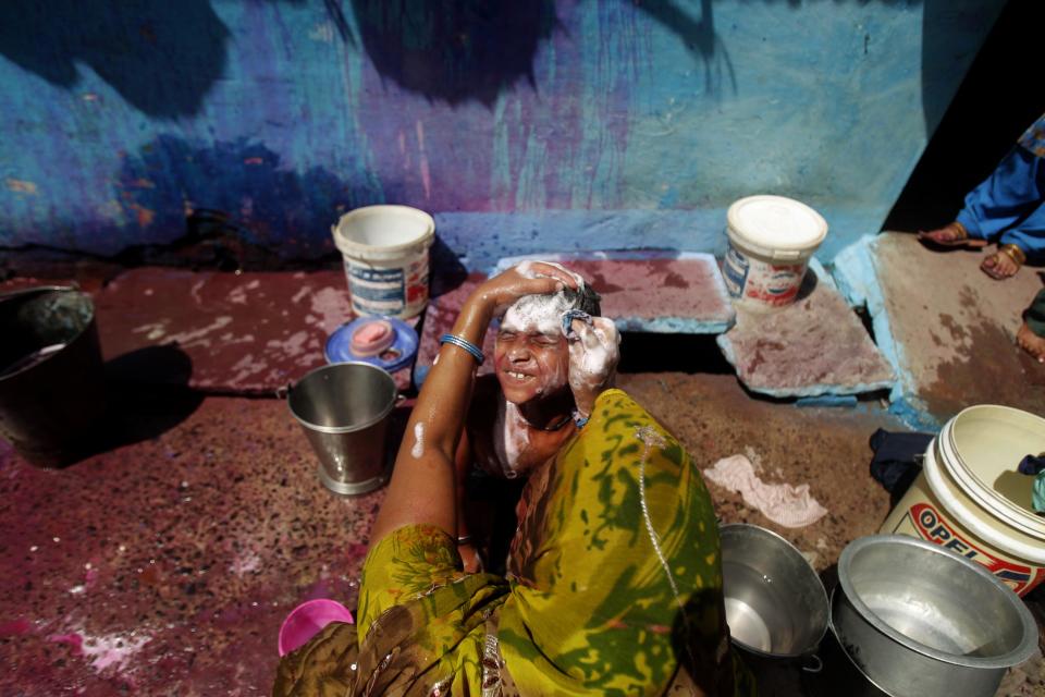 In this photo taken Monday, March 12, 2012, a woman gives bath to her son at a shanty near the abandoned Union Carbide factory at J.P. Nagar, a neighborhood that was affected by the 1984 gas leak because of its proximity to the factory in Bhopal, India. The survivors of the tragedy of 27 years ago, with their lingering illnesses, sick children and dead relatives, faded away from the world's memory, even as their suffering went on. Now, though, they have seized on a new chance to force their plight in front of the world, the London Olympics. (AP Photo/Rafiq Maqbool)