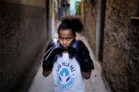 Deisiane, 9, poses for a photograph in an alley, also known as "viela", in the Mare favela of Rio de Janeiro, Brazil, June 2, 2016. REUTERS/Nacho Doce