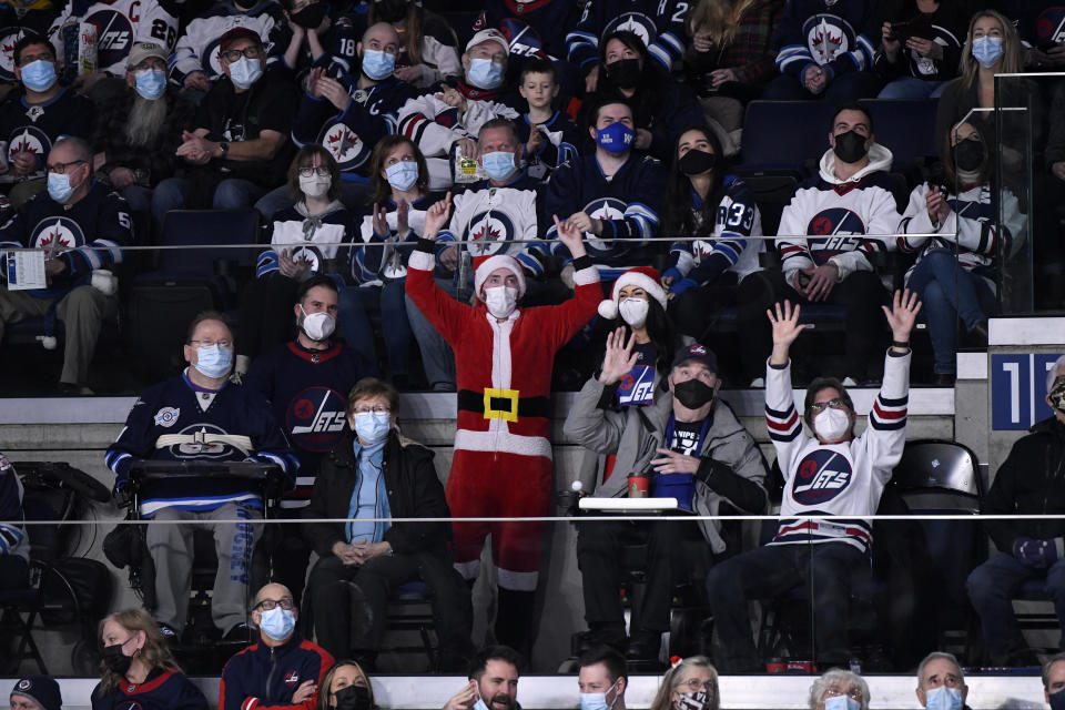 Winnipeg Jets fans cheer during the second period of NHL hockey game action against the St. Louis Blues in Winnipeg, Manitoba, Sunday, Dec. 19, 2021. (Fred Greenslade/The Canadian Press via AP)