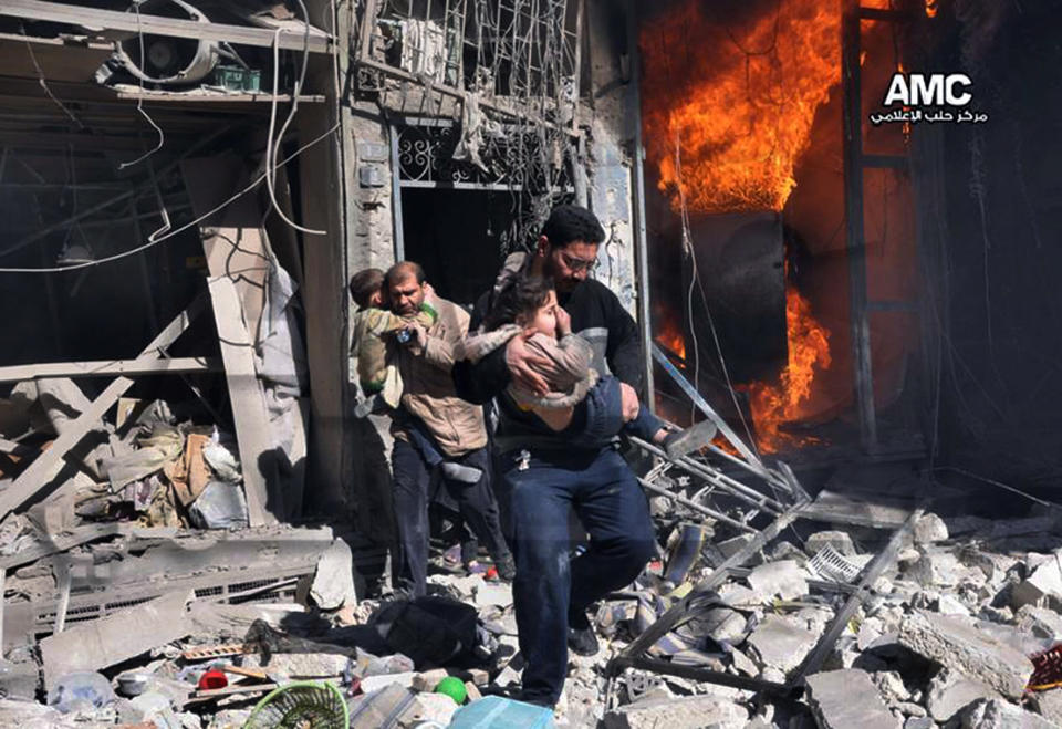 In this photo provided by the anti-government activist group Aleppo Media Center (AMC), which has been authenticated based on its contents and other AP reporting, Syrian men help survivors out of a destroyed building after a Syrian forces warplane's attack in Aleppo, Syria, Saturday, Feb. 8, 2014. Syrian military aircraft dropped barrels bombs on rebel-held areas in the northern city of Aleppo on Saturday. (AP Photo/Aleppo Media Center AMC)