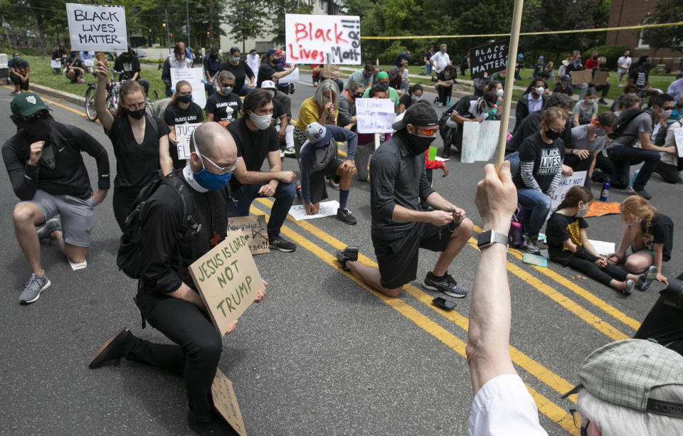People including Kevin Antlitz, an Anglican priest, left, take a knee during a protest of the visit of President Donald Trump to the Saint John Paul II National Shrine, Tuesday, June 2, 2020, in Washington. Many demonstrators present said they were dismayed when Trump staged a visit to the historic St. John's Church across from the White House and held up a Bible after authorities had cleared the area of peaceful protesters. Protests continue over the death of George Floyd, who died after being restrained by Minneapolis police officers. (AP Photo/Jacquelyn Martin)