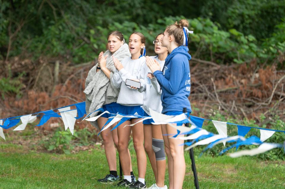 Harper Creek runners cheer for their teammates during a meet at Harper Creek High School on Saturday, Aug. 26, 2023.