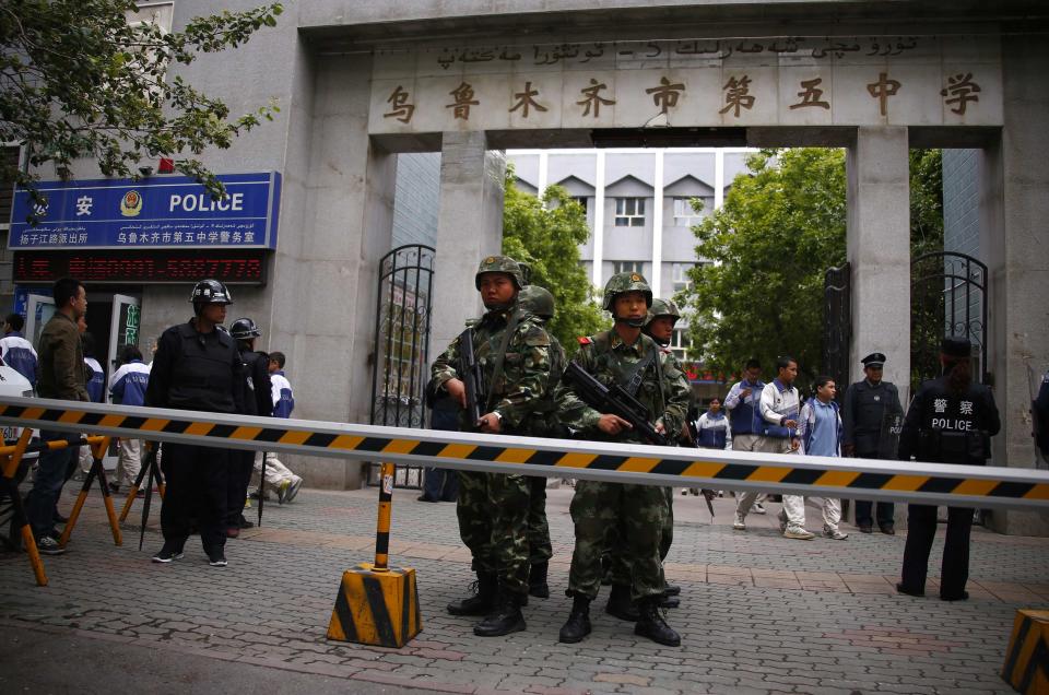 Paramilitary policemen stand guard in front of Urumqi No. 5 middle school after Thursday's attack in downtown Urumqi, Xinjiang Uighur Autonomous Region May 23, 2014. Five suicide bombers carried out the attack which killed 31 people in the capital of China's troubled Xinjiang region, state media reported a day after the deadliest terrorist attack to date in the region. REUTERS/Petar Kujundzic (CHINA - Tags: MILITARY CIVIL UNREST CRIME LAW EDUCATION TPX IMAGES OF THE DAY)