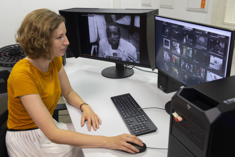 In this Wednesday, June 17, 2020 photo creative producer Valerie Fidler works on the digitized film weekly show 'Der Augenzeuge - The Eyewitness' (1963/21) at PROGRESS Film, in Leipzig, Germany. A new project is underway to digitize thousands of East German newsreels, documentaries and feature films 30 years after Germany’s reunification. The movies that are being scanned, transcribed and posted online provide a look inside a country that no longer exists but was a critical part of the Cold War. (AP Photo/Jens Meyer)