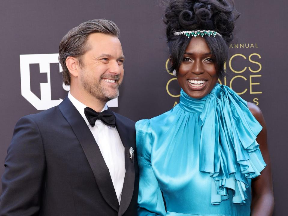 Joshua Jackson and Jodie Turner-Smith smile while posing for photos together on the red carpet.