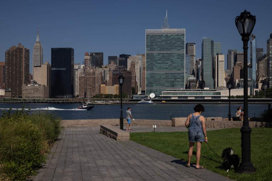 People walk at Gantry Plaza State Park in Queens, New York, on July 19, 2022, as a heat wave continues in Europe and North America. (Photo by YUKI IWAMURA/AFP via Getty Images)