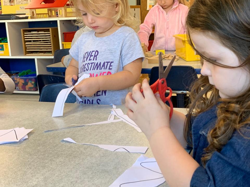 Using safety scissors, preschoolers Melanee and Gracie cut out shapes during an activity session at the Pine Street KinderCare Center in Waukesha. Activities such as this are part of the center's emphasis on learning.