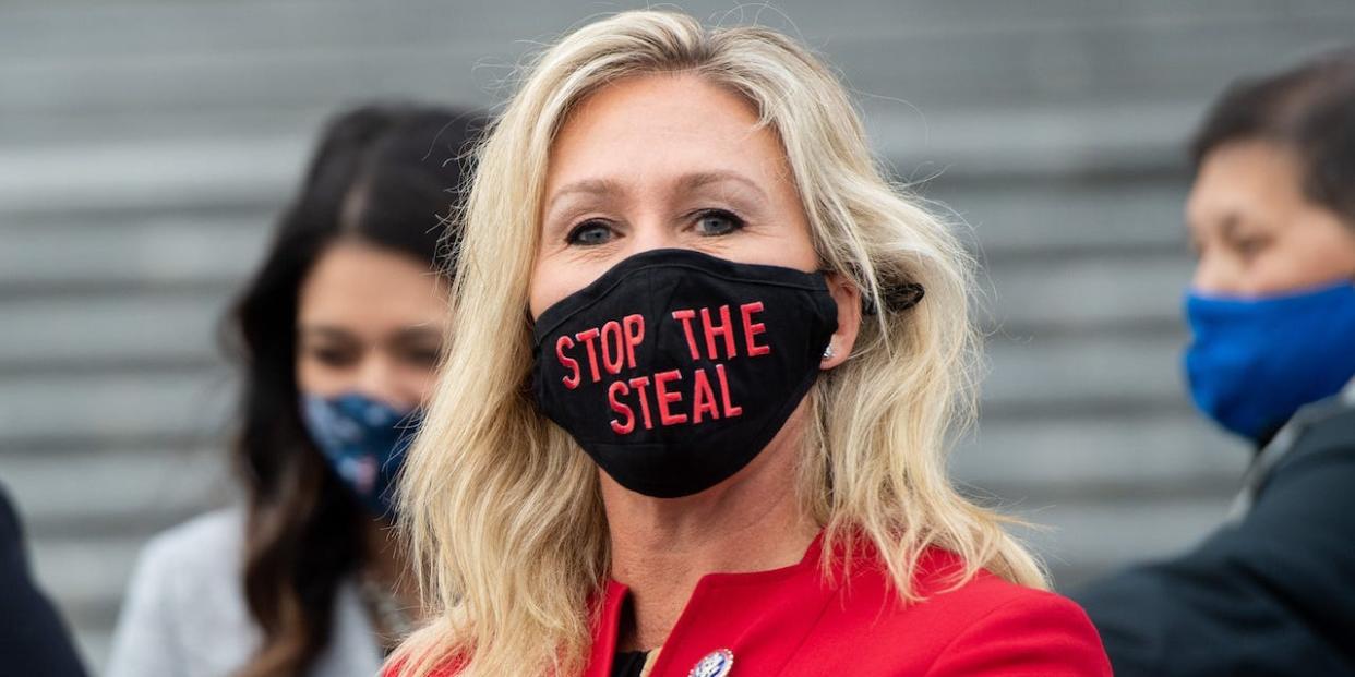 Marjorie Taylor Greene, Republican of Georgia, holds up a "Stop the Steal" mask while speaking with fellow first-term Republican members of Congress on the steps of the US Capitol in Washington, DC, January 4, 2021.